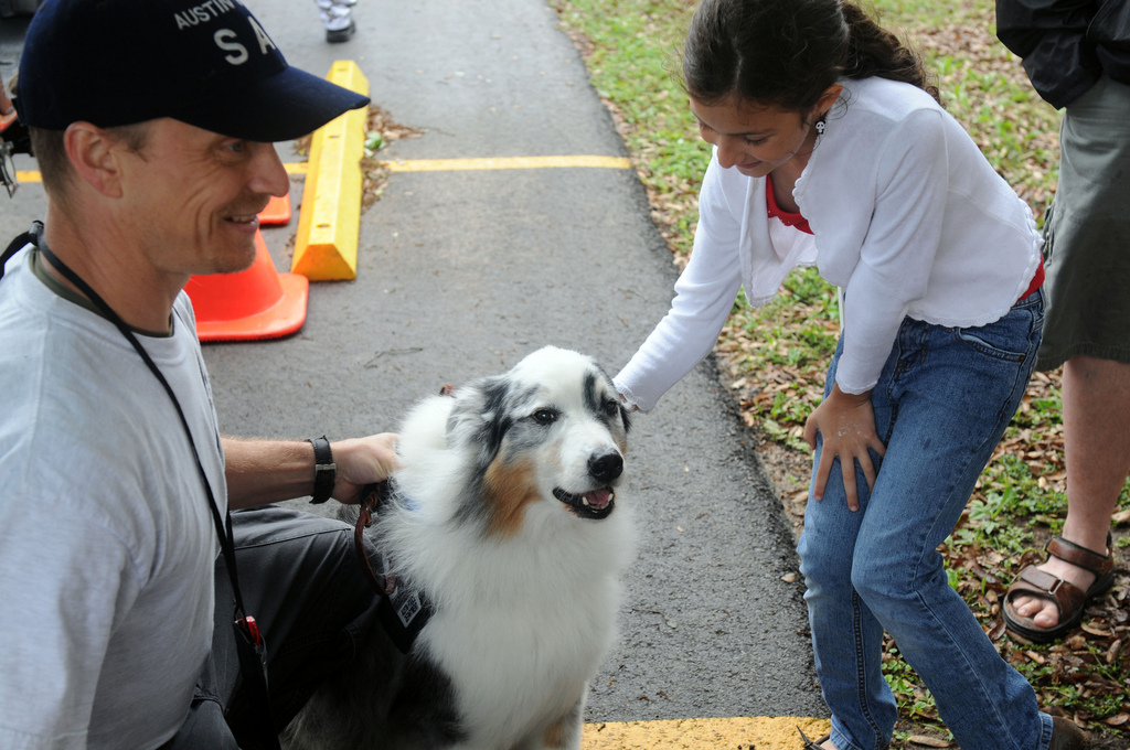 Search and Rescue dog Kobe enjoys pets from Rose J Curtis at the American Heroes Celebration in Austin. Bren Wilson, Kobe's trainer, left, said Kobe likes the attention.